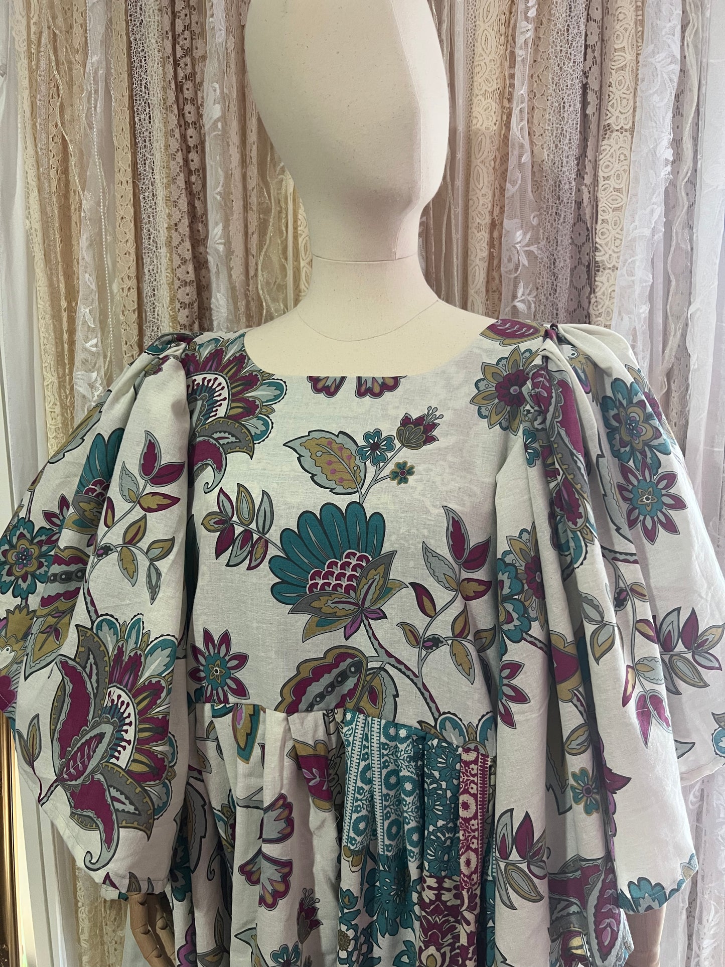 Mannequin wearing a floral-patterned dress with a neutral background