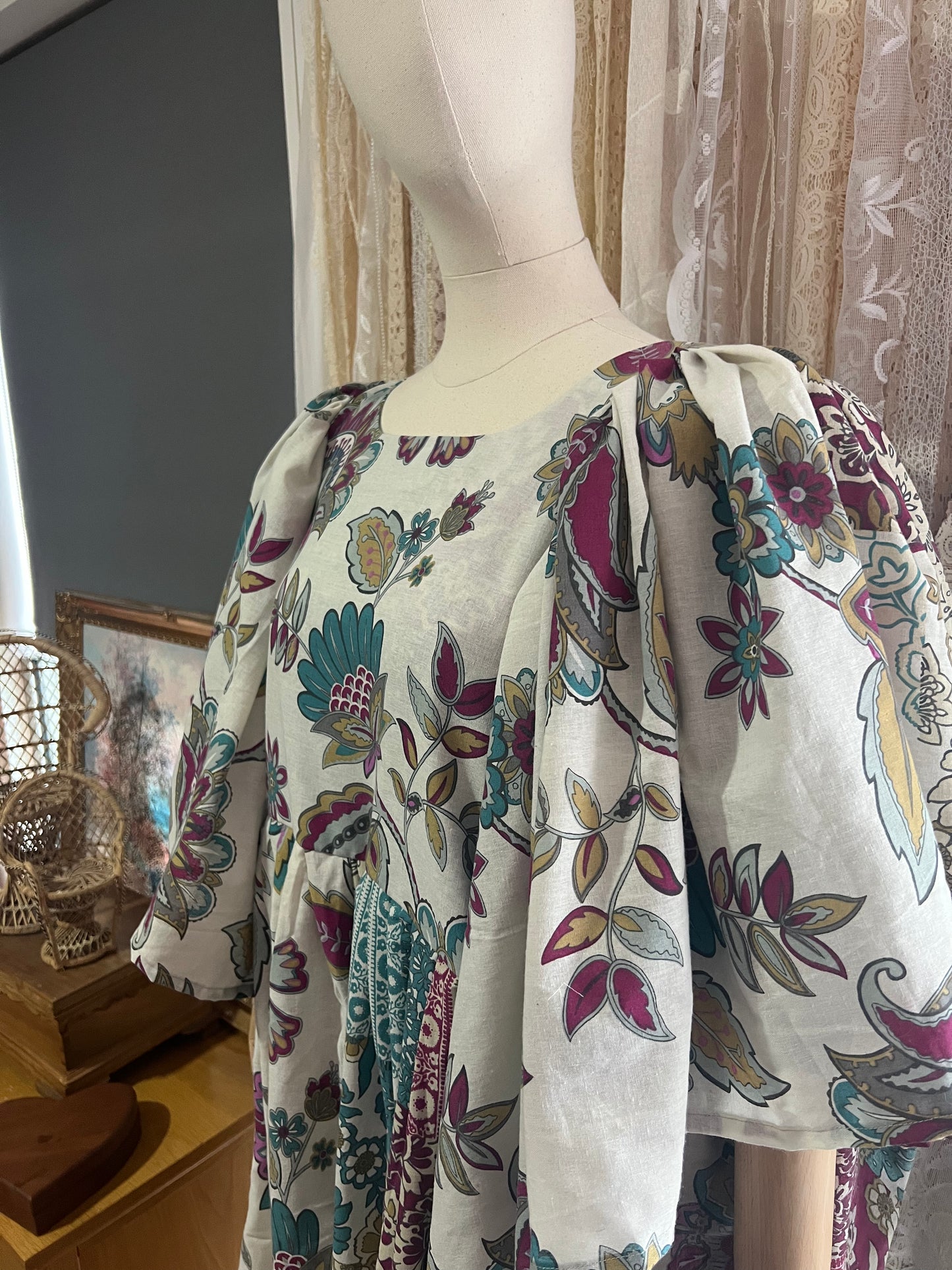 Mannequin wearing a floral dress with a blurred indoor background