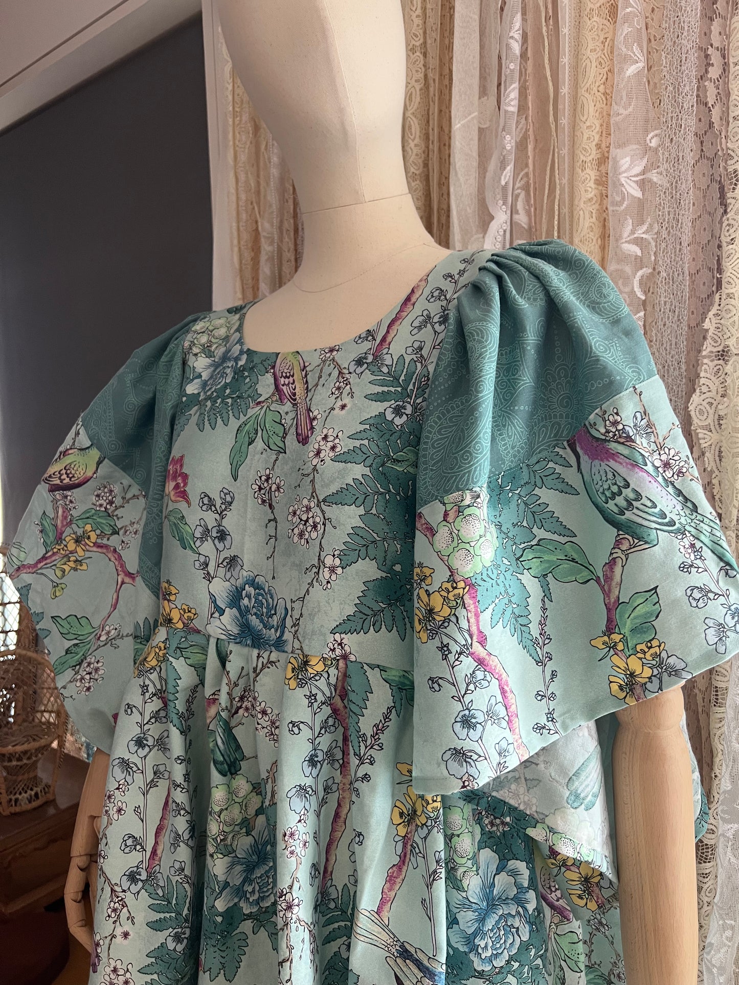 Mannequin wearing a floral dress with puff sleeves against a neutral background