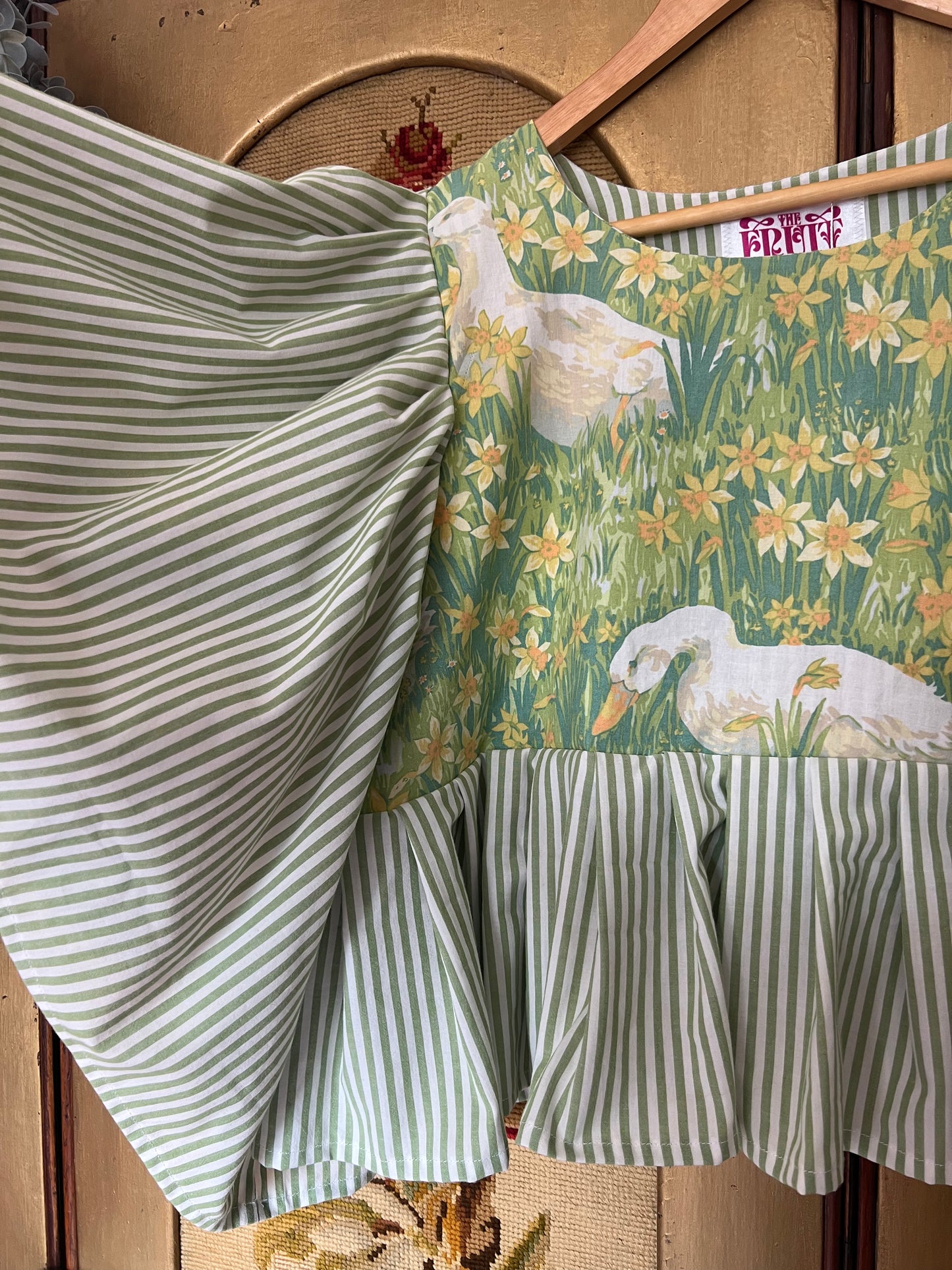 Top with duck design and green striped pattern on a wooden surface