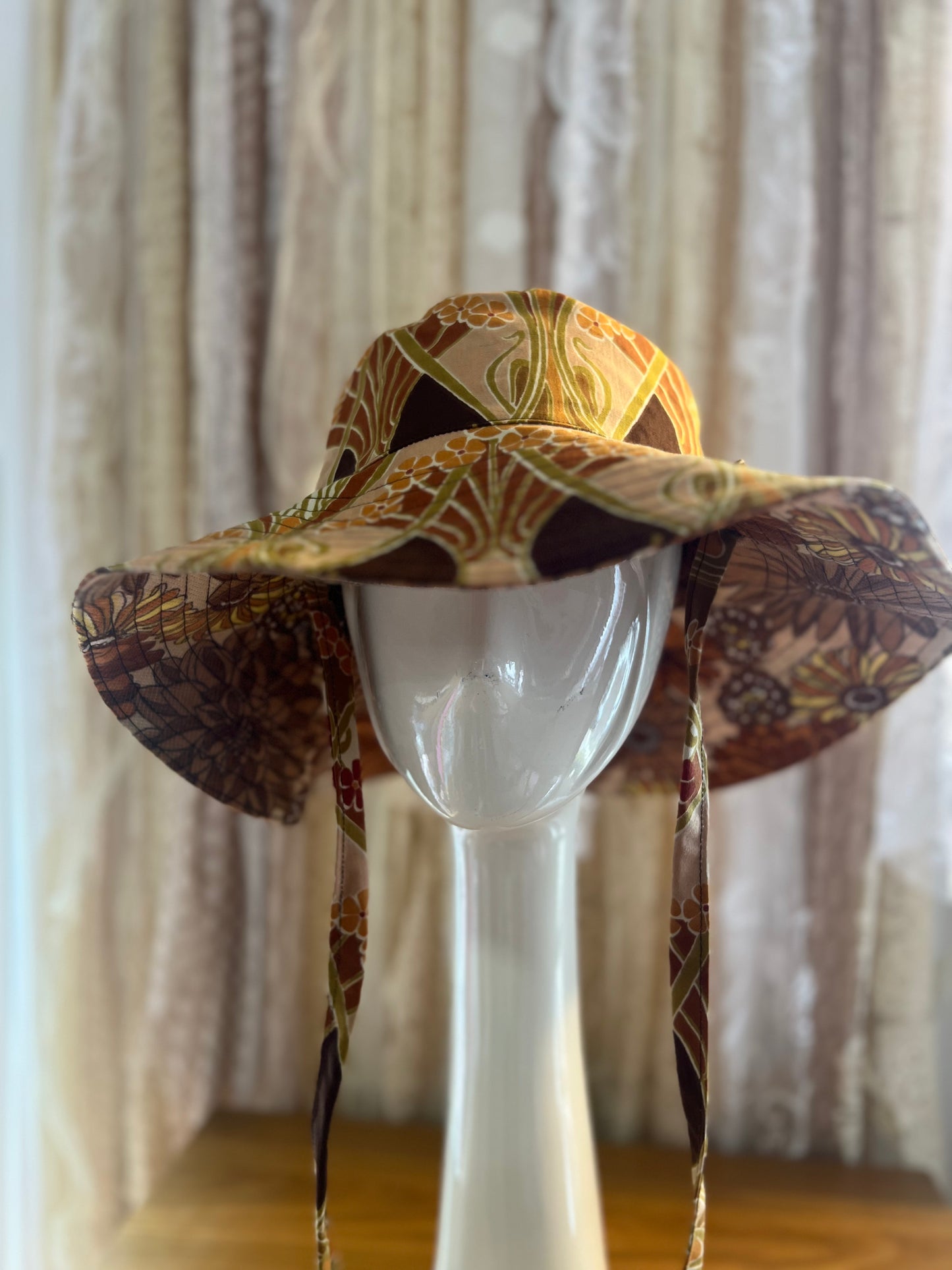 Decorative hat on a mannequin head against a neutral background