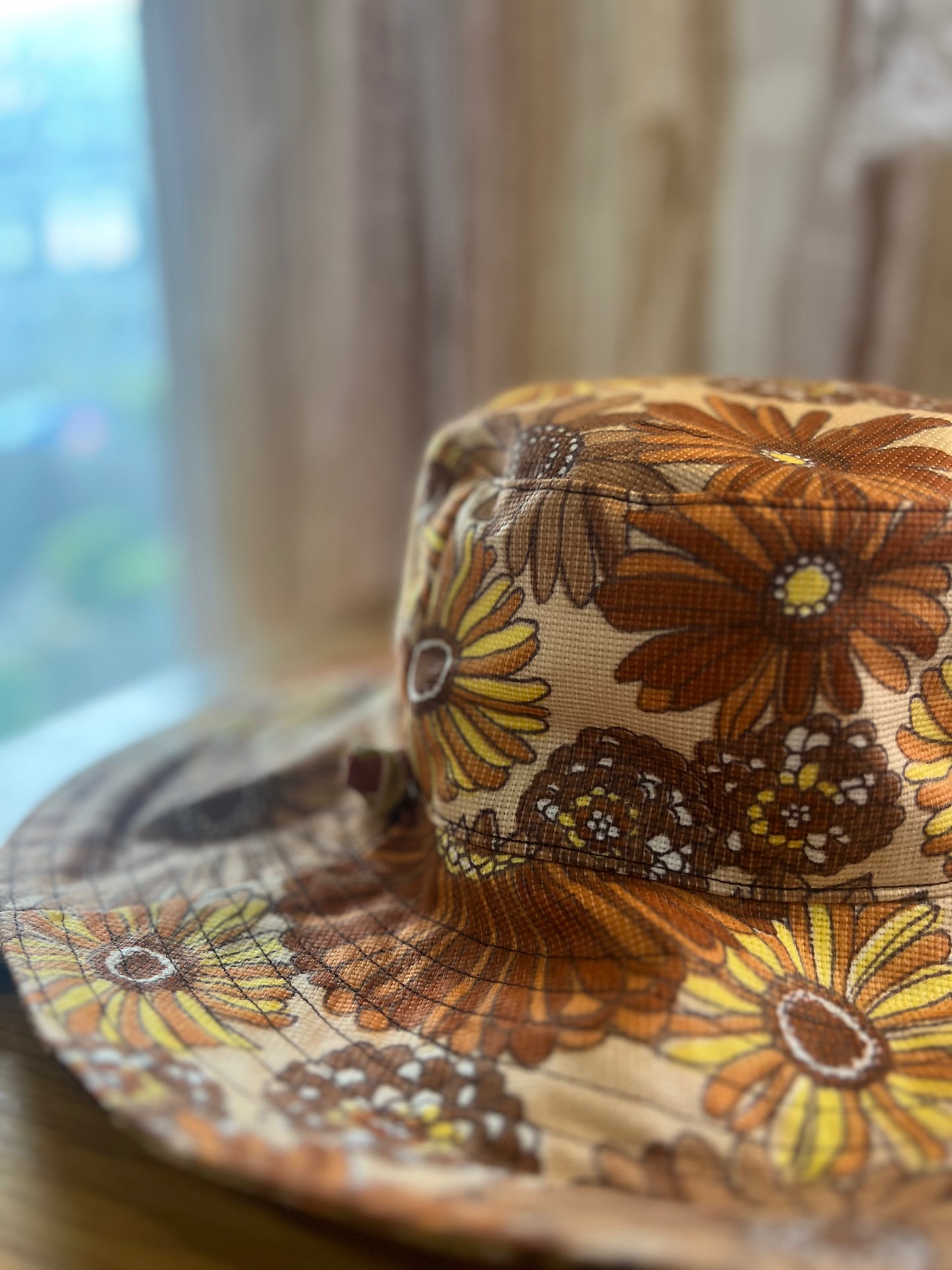 Floral-patterned hat on a wooden surface with a blurred background