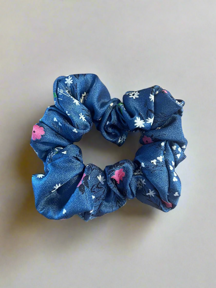 Blue scrunchie with floral pattern on a white surface