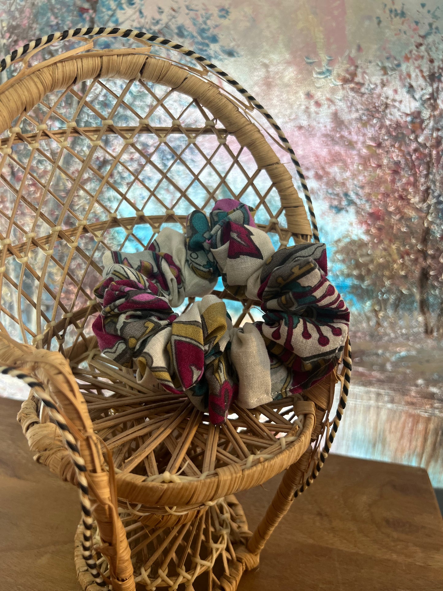 Wicker chair with patterned scrunchies on a textured surface