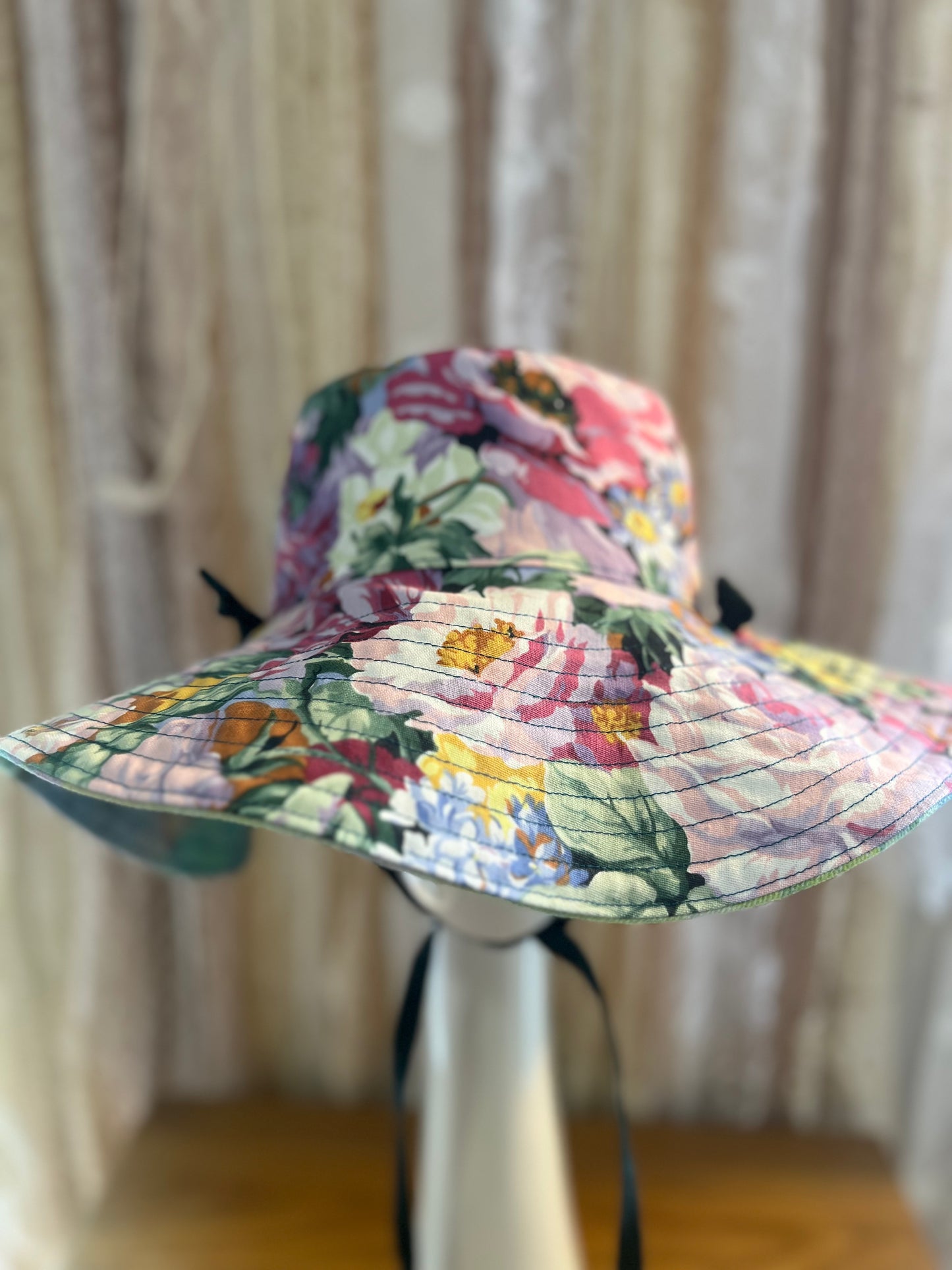 Floral patterned sun hat on a mannequin against a neutral background