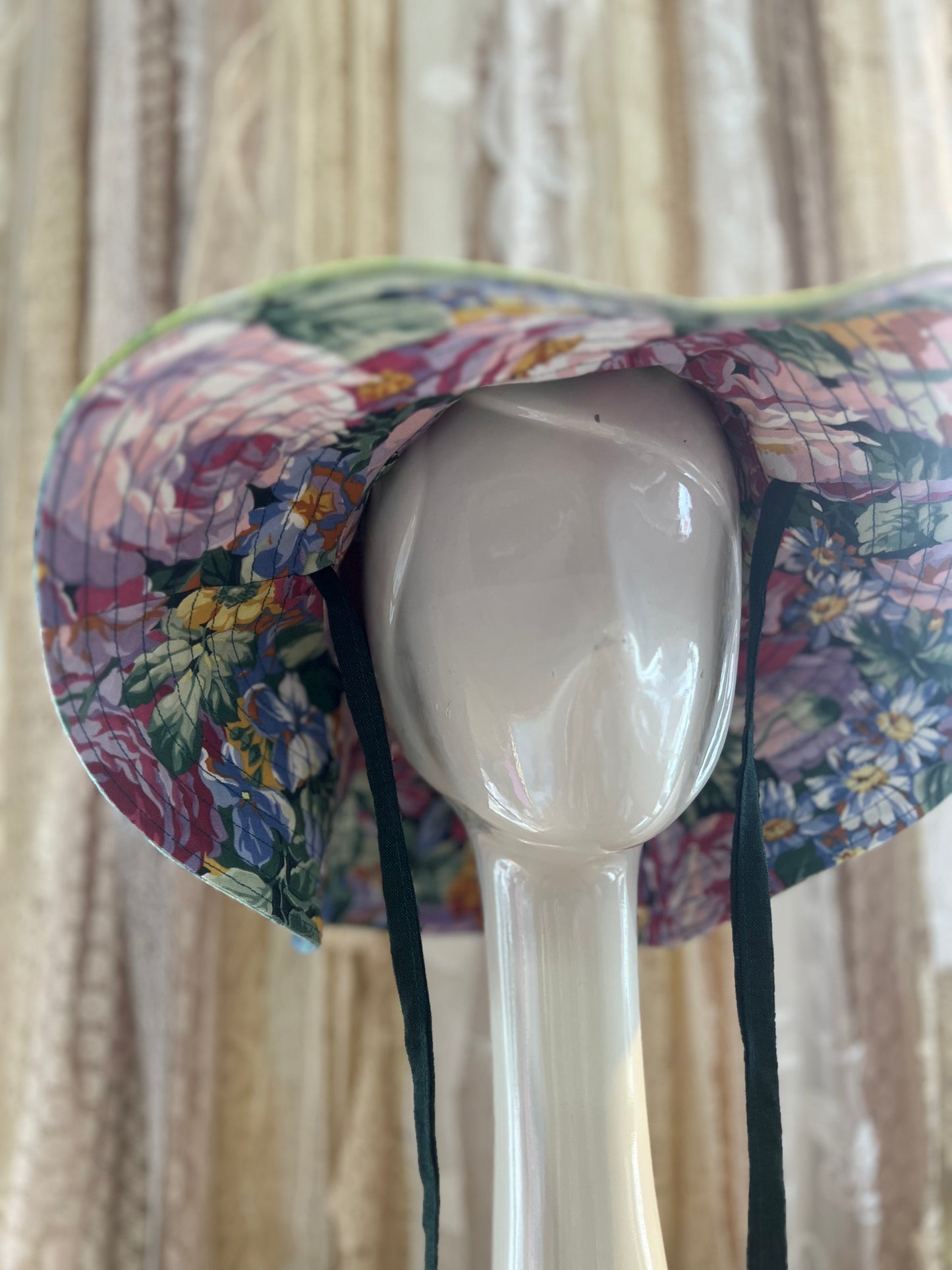 Floral-patterned hat on a mannequin head with a neutral background