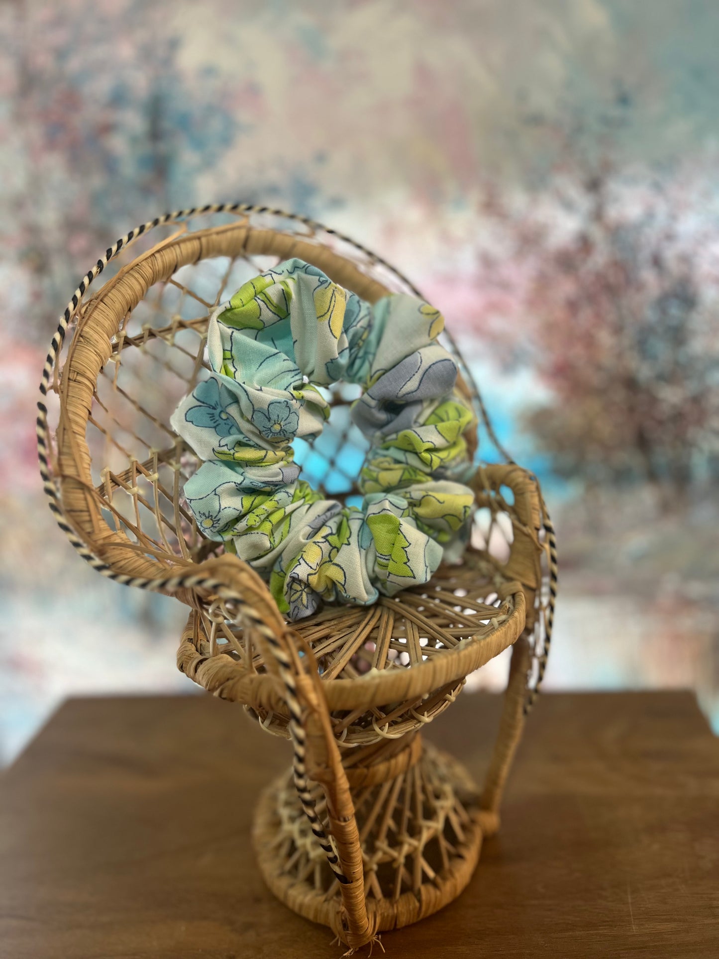 Decorative scrunchie on a woven mini chair on a wooden surface.