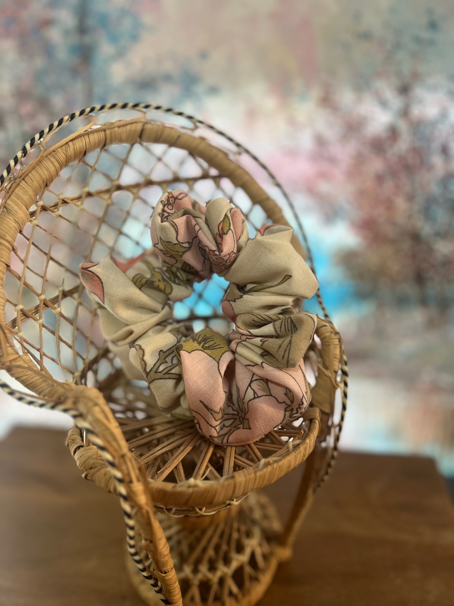 Floral scrunchie sitting on a woven chair with a blurred background