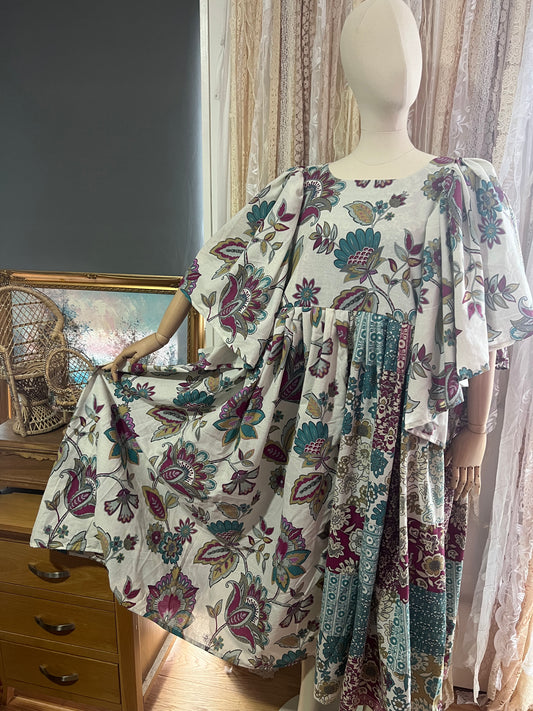 Mannequin wearing a floral kimono-style garment in a room with furniture and decor.