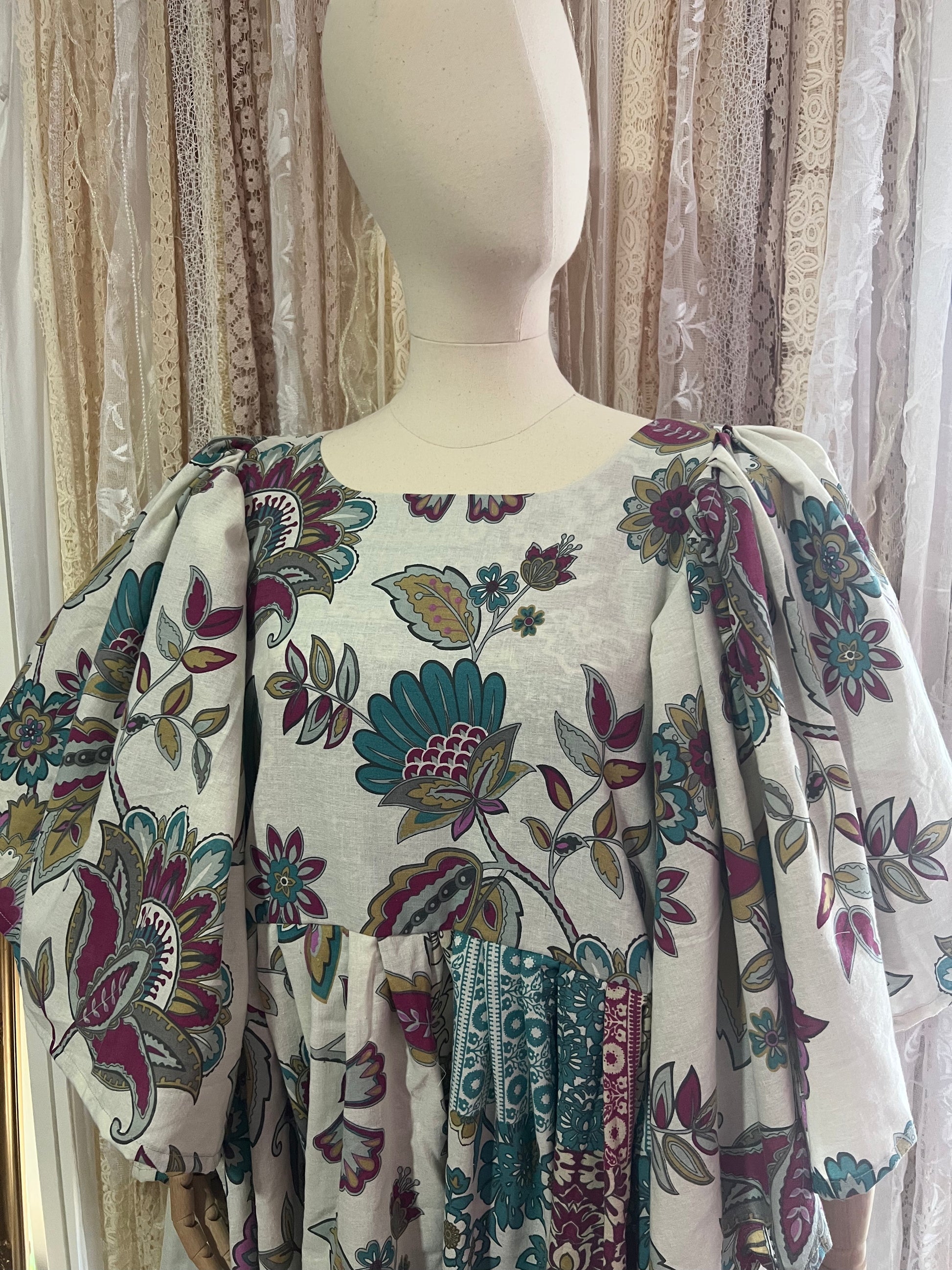 Mannequin wearing a floral-patterned dress with a neutral background