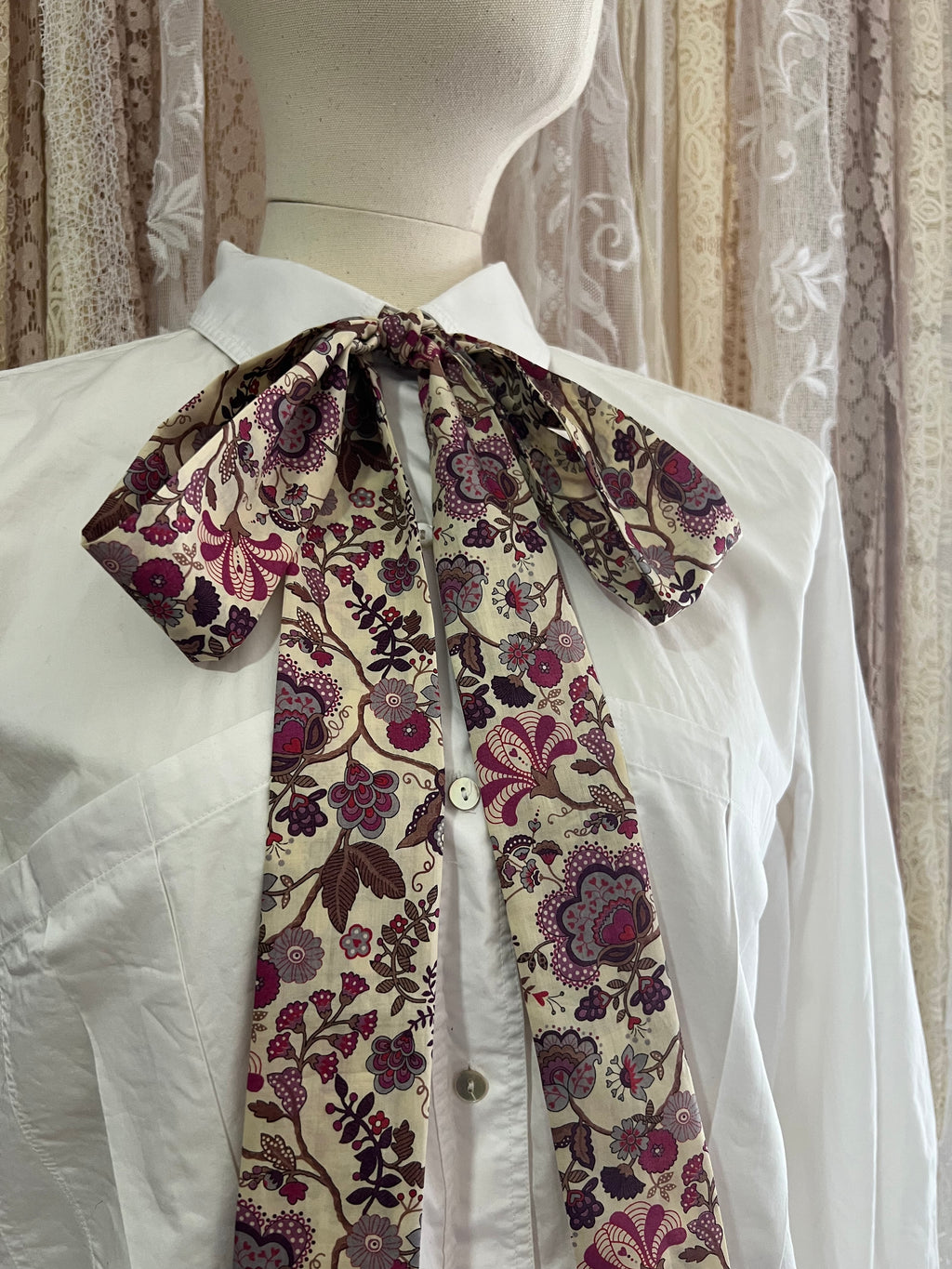 Floral-patterned tie on a white shirt with a mannequin background