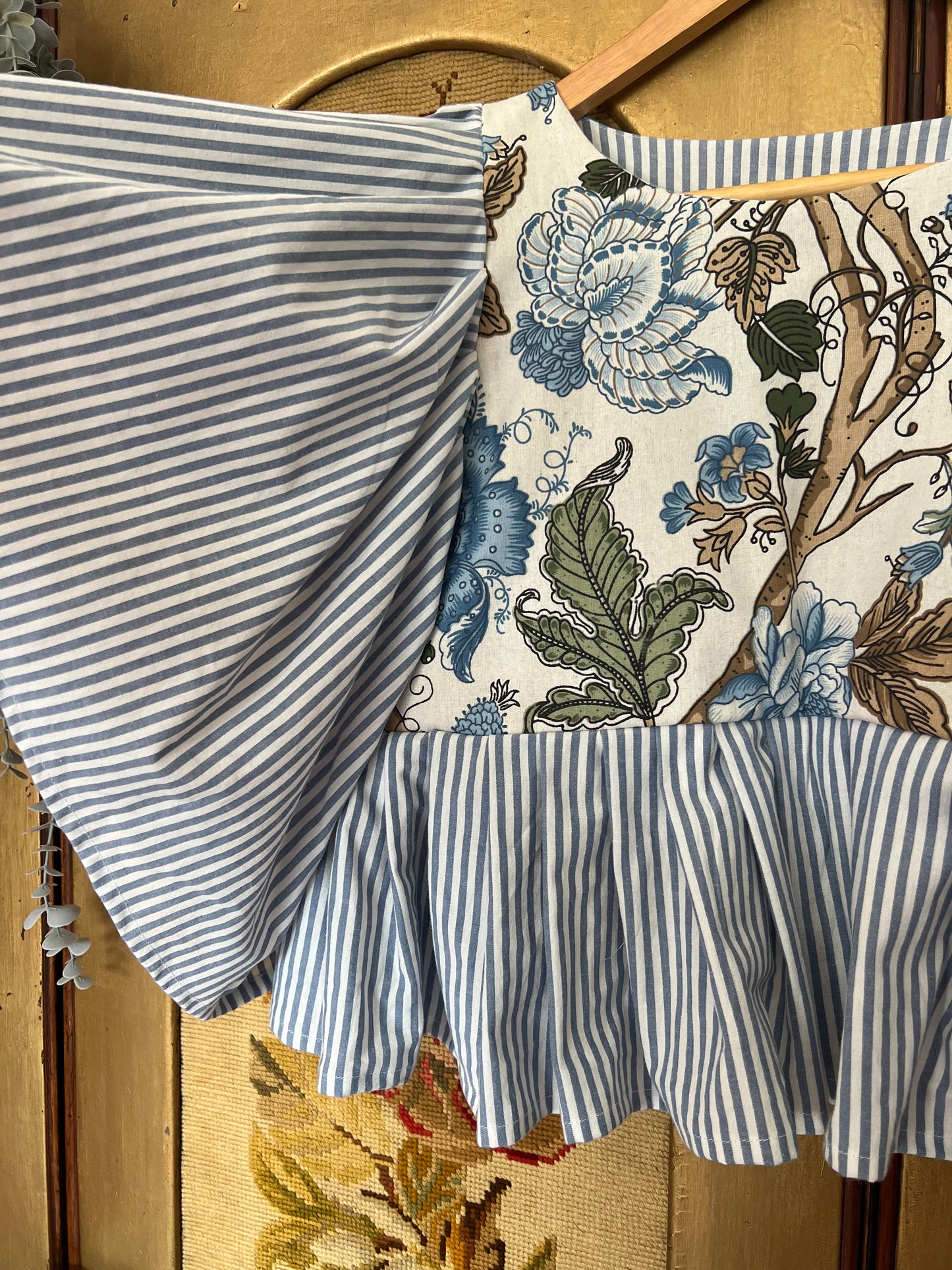 Fabric with blue and white stripes and floral pattern on a wooden surface