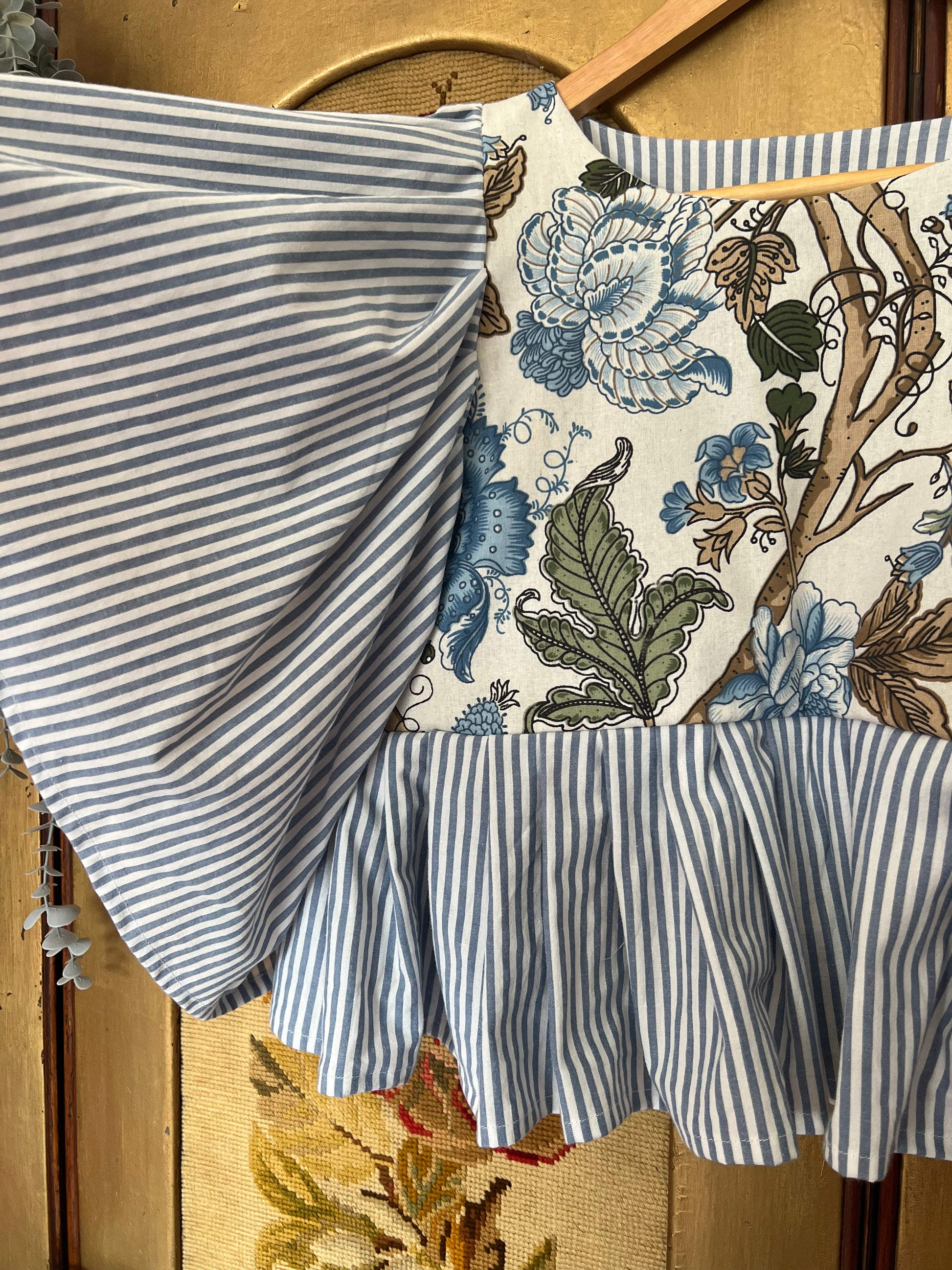 Fabric with blue and white stripes and floral pattern on a wooden surface