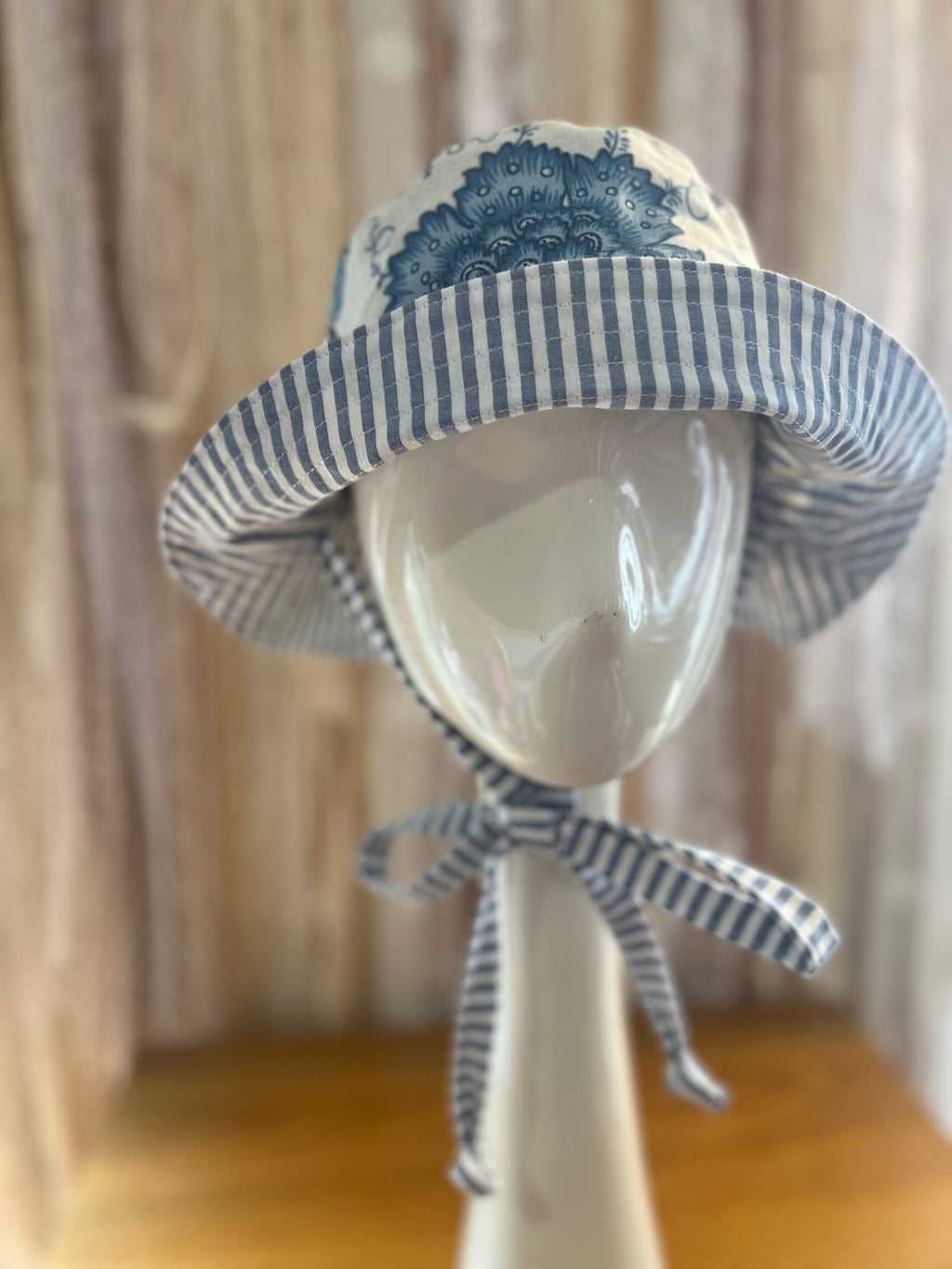 Blue and white stripe and floral bucket hat on a mannequin head
