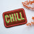 Embroidered patch with 'CHILL' slogan in green and pink.