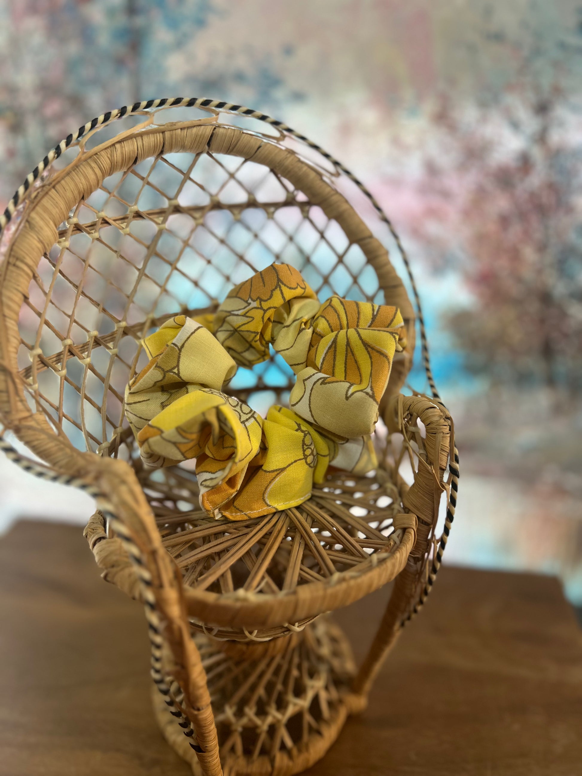 Wicker chair with yellow scrunchie on a blurred background