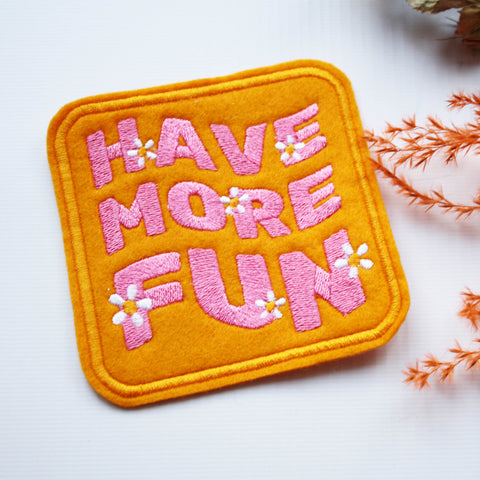 Iron or sew on patch with a bright pink 'HAVE MORE FUN' slogan embroidery