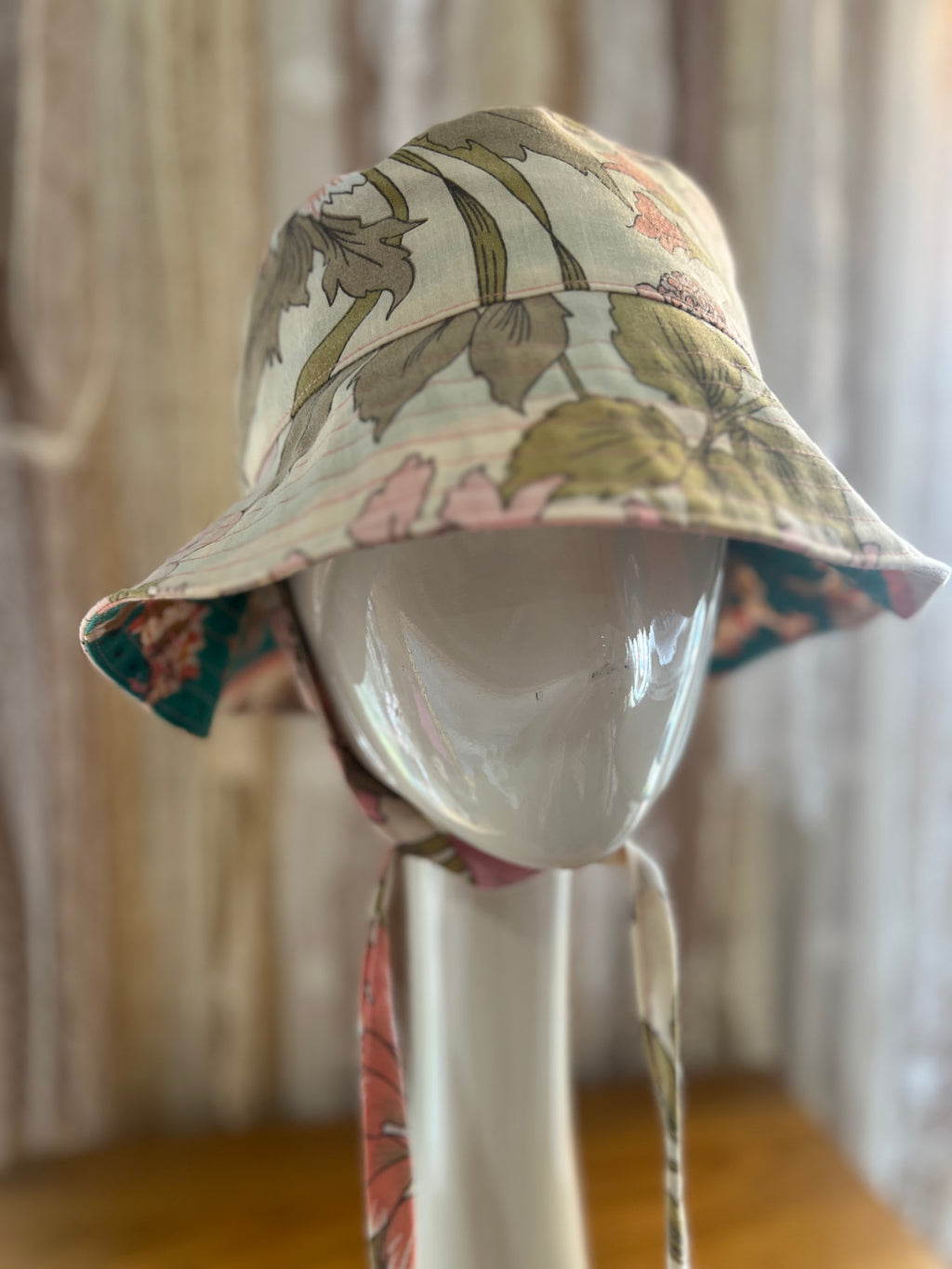 Floral-patterned bucket hat on a mannequin head against a neutral background