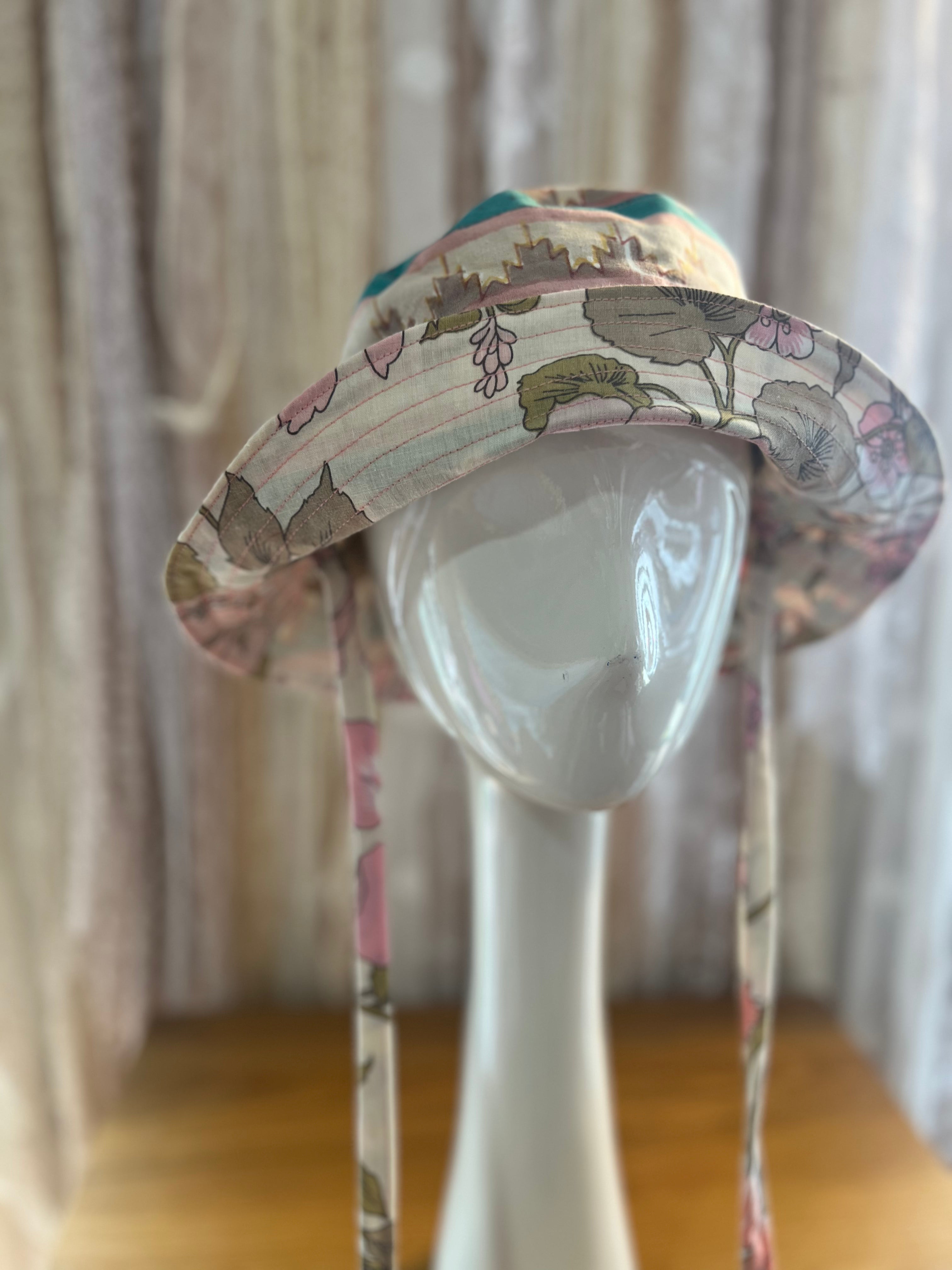Floral-patterned sun hat on a mannequin head against a neutral background
