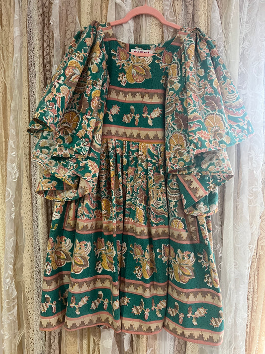 Traditional patterned dress on a hanger against a neutral background