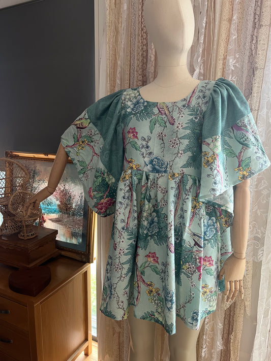Mannequin wearing a floral dress with puff sleeves in a room setting.