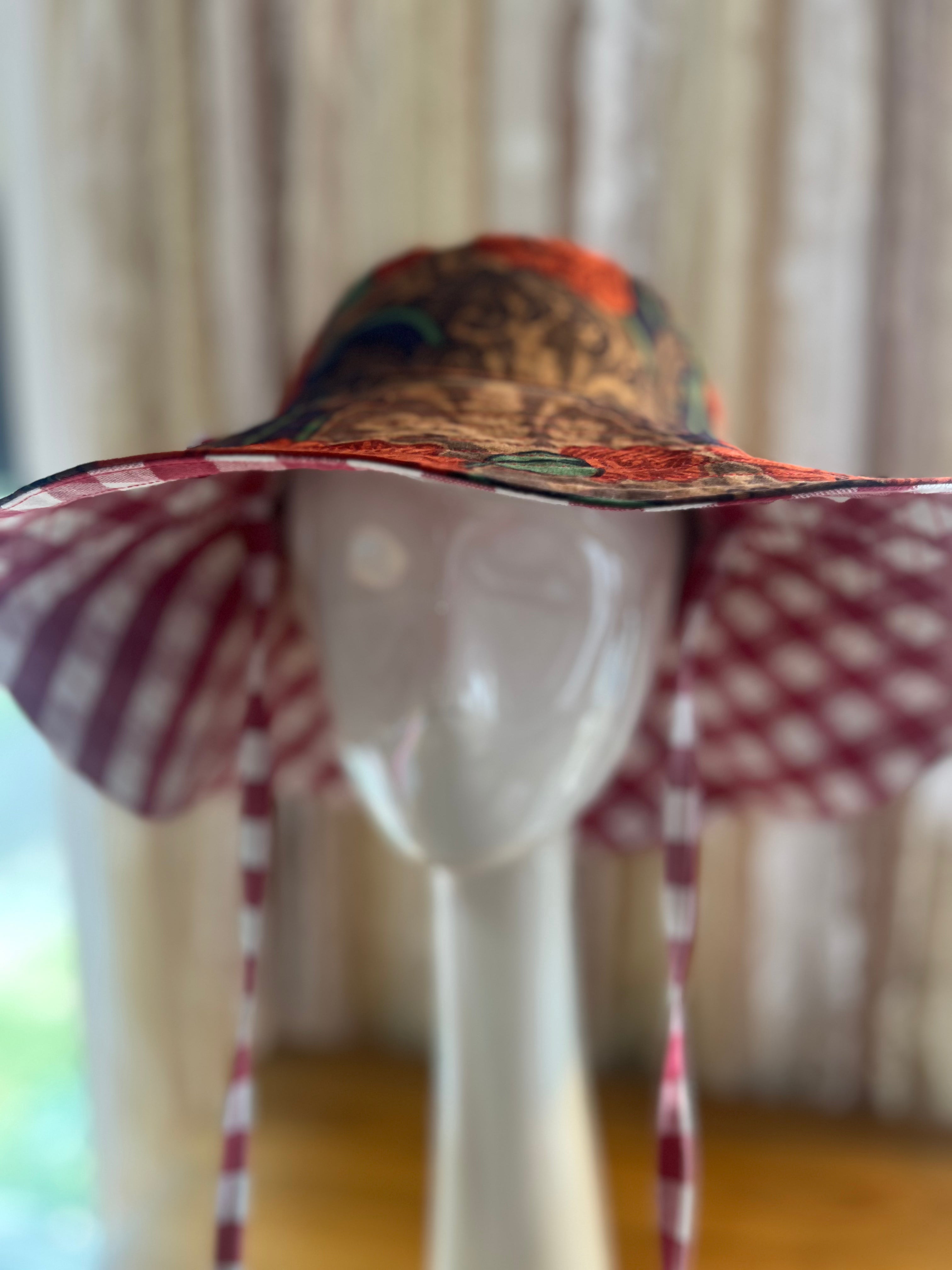 Colorful sun hat with a pattern on a mannequin head against a neutral background