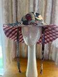 Colorful patterned sun hat on a mannequin head against a neutral background