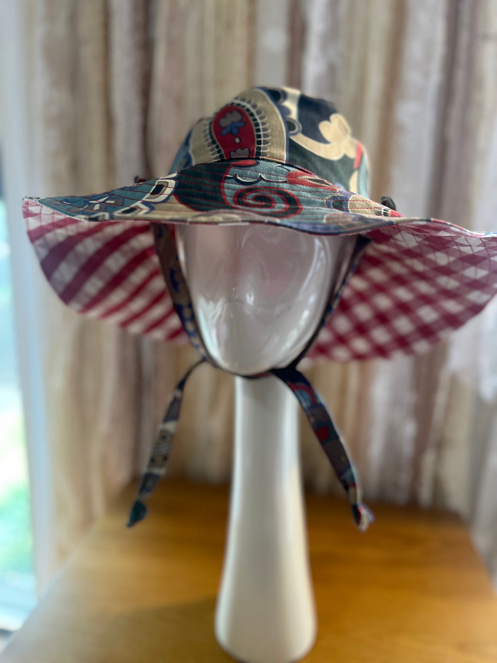 Colorful sun hat on a mannequin head with a neutral background