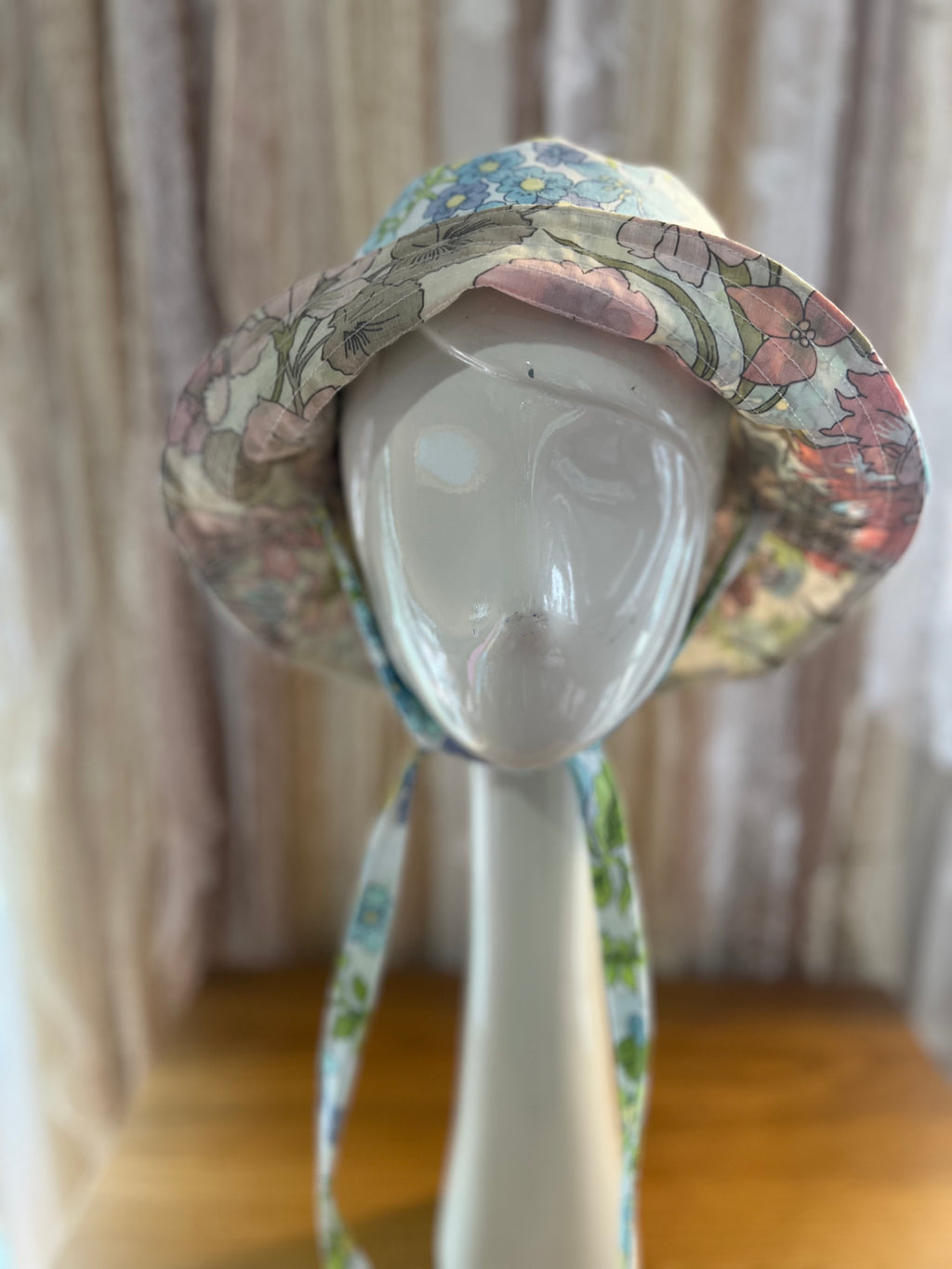 Floral-patterned hat on a mannequin head with a neutral background