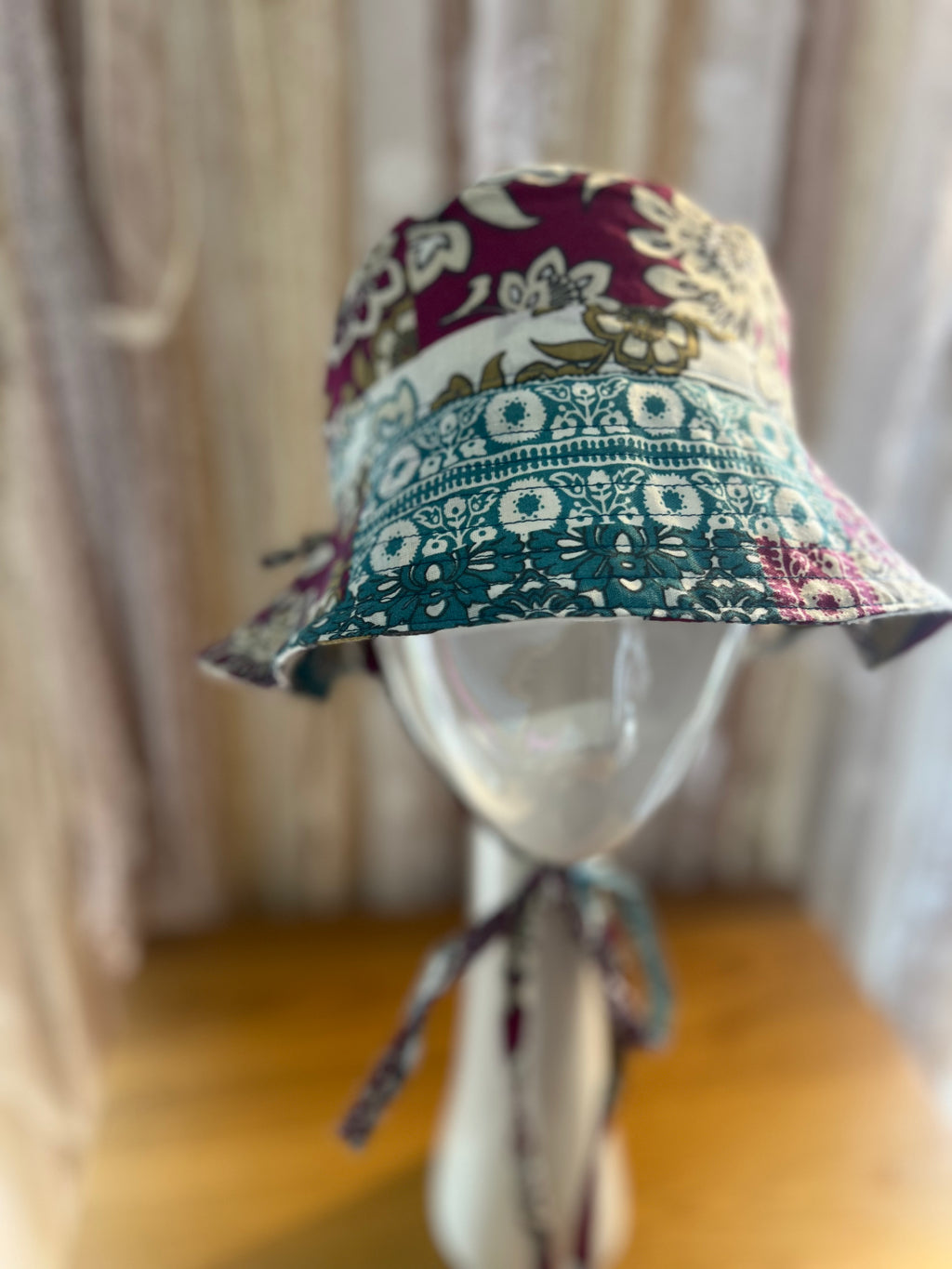 Colorful patterned bucket hat on a mannequin against a neutral background