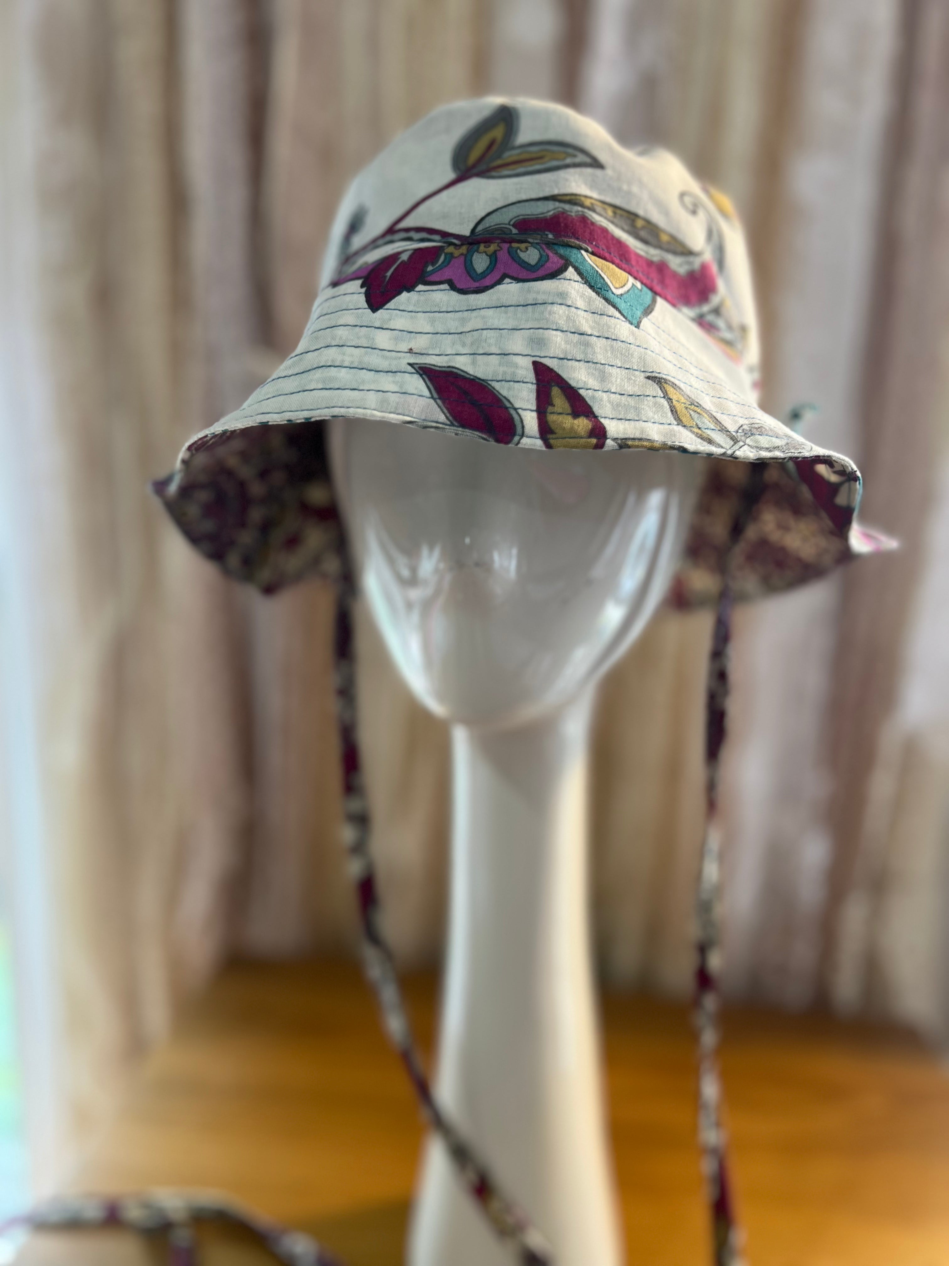 Floral-patterned bucket hat on a mannequin head with a neutral background
