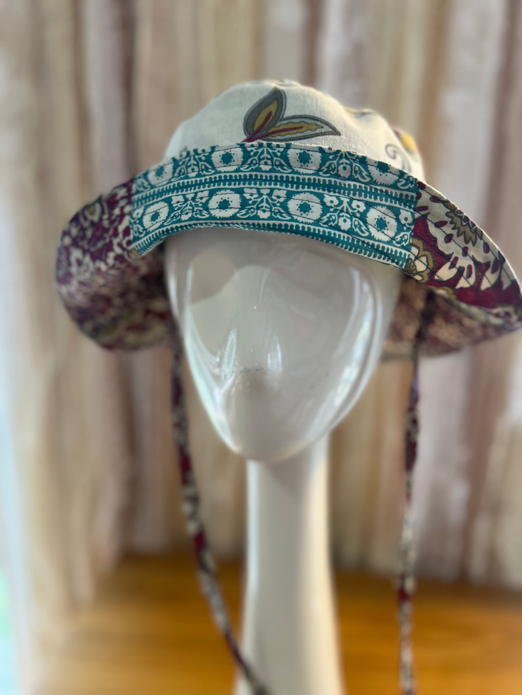 Colorful patterned hat on a mannequin head against a neutral background