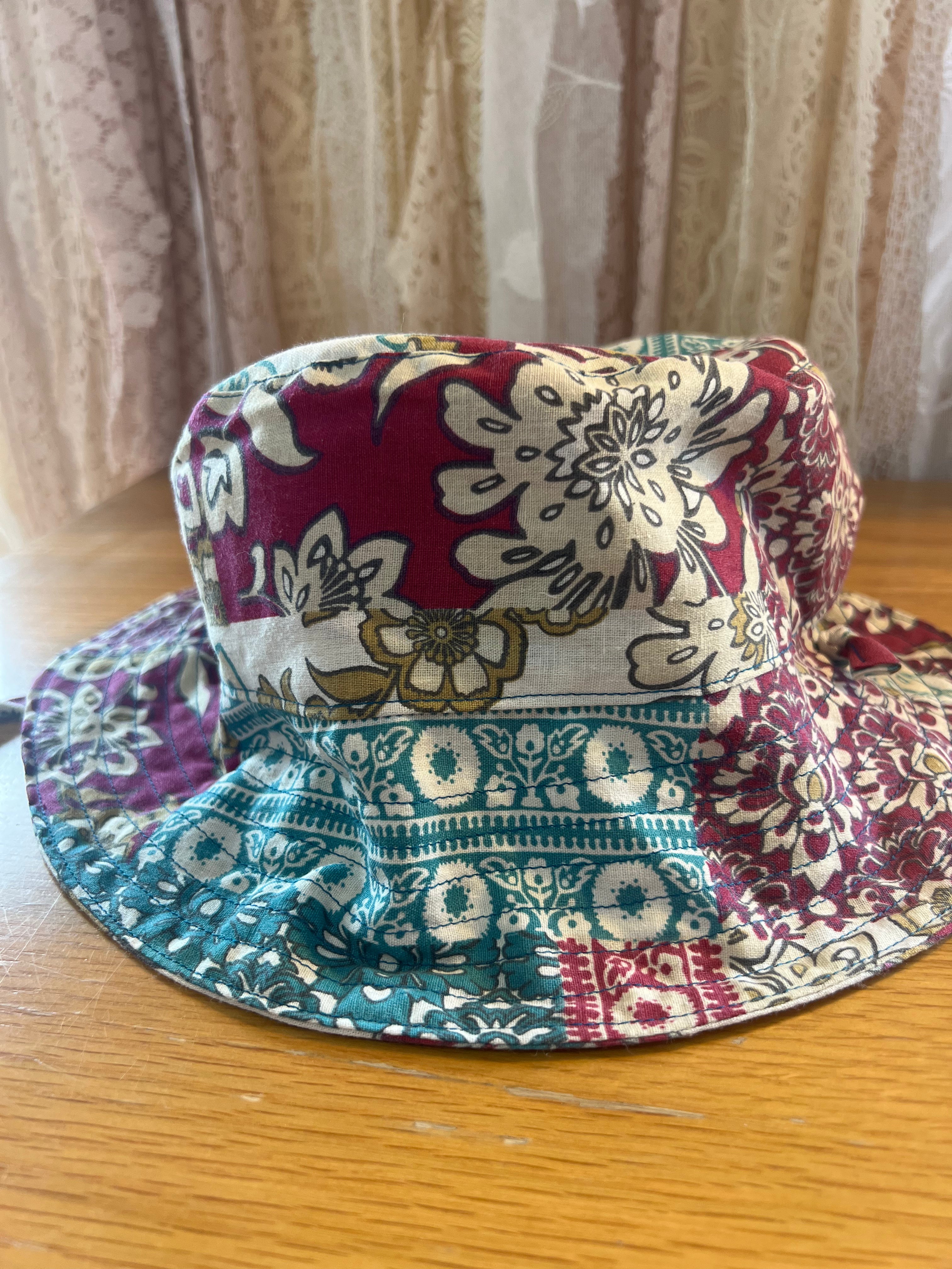 Colorful patterned bucket hat on a wooden surface with a neutral curtain background