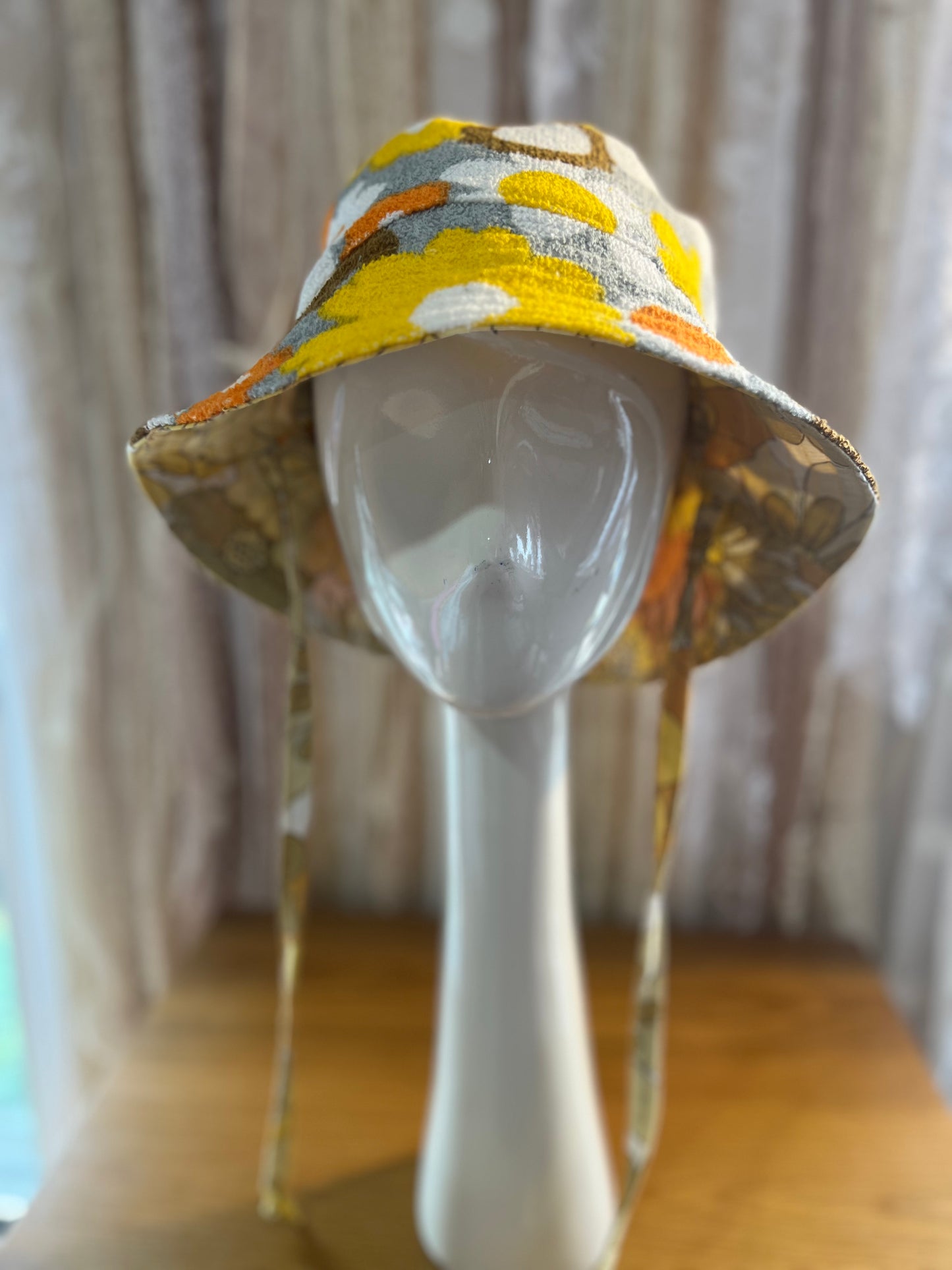 Colorful bucket hat on a mannequin head against a neutral background