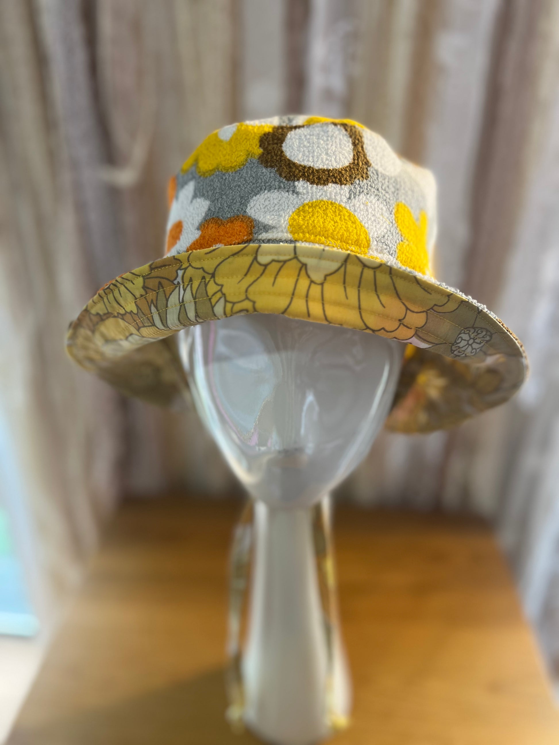 Floral-patterned bucket hat on a mannequin head against a neutral background