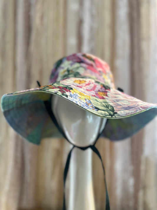 Colorful floral sun hat on a mannequin head against a neutral background